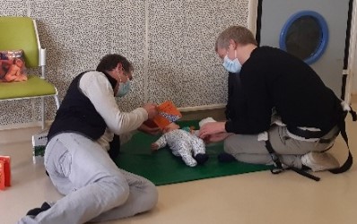 Deux adultes lisant à un bébé en PMI