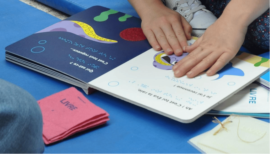 mains d'enfant sur livre les illustrations tactiles d'un livre ouvert en braille